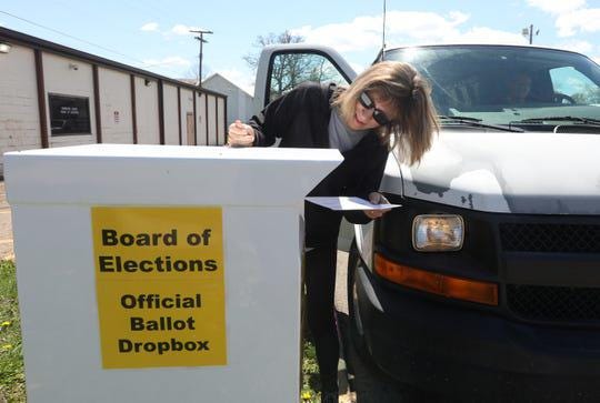 Cindy Massie puts her ballot in the drop box outside the Coshocton County Board of Elections on Monday. (Photo: Chris Crook/Tribune)