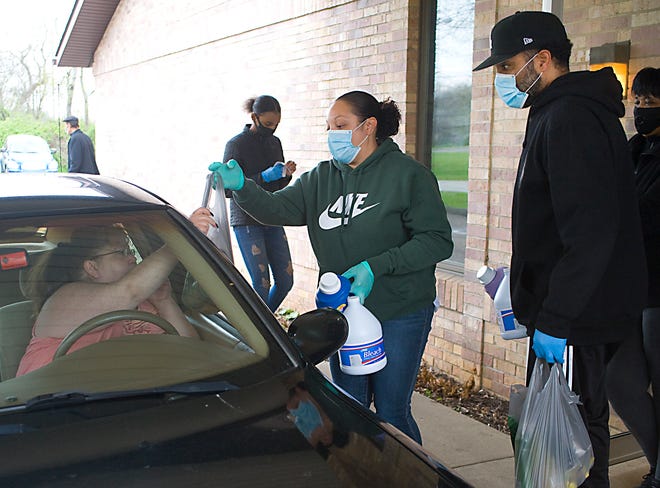 Johnette Telli and Nick Myers III load cars with cleaning supplies during Operation Lightening the Load Essential Household Cleaning Products giveaway Wednesday at Temple of Faith Church of God in Christ. The church had enough supplies donated to help 200 households.