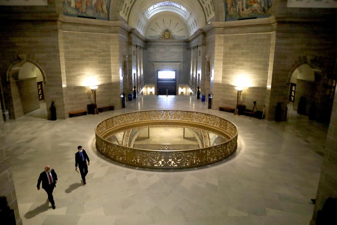 People wear protective masks Monday as they walk in the rotunda at the state Capitol Members of the House returned Monday to begin debate on the budget for the upcoming fiscal year, a daunting task amid declining revenue because of the coronavirus. [Jeff Roberson/Associated Press]