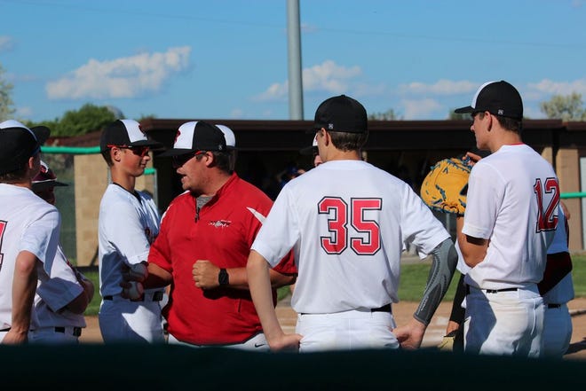 In this June 25, 2019 file photo, Tim Ronning Post 24 head coach Tanner Carpenter (in red) speaks with the team in between innings in Devils Lake.
