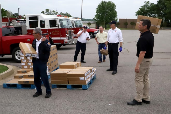 Volunteers with the Van Buren Police Department and Fire Department help distribute more than 25,000 pounds of donated Smithfield Foods pork products, Tuesday, April 28, 2020, at the River Valley Regional Food Bank pop-up pantry site at the Van Buren High School. The RVRFB will hold another pop-up distribution at the Waldron High School, Thursday, April 30, 2020, at 10 a.m., and plans to give away more than 36,000 pounds of Tyson chicken products. It is open to anyone in need from the area. [JAMIE MITCHELL/TIMES RECORD]
