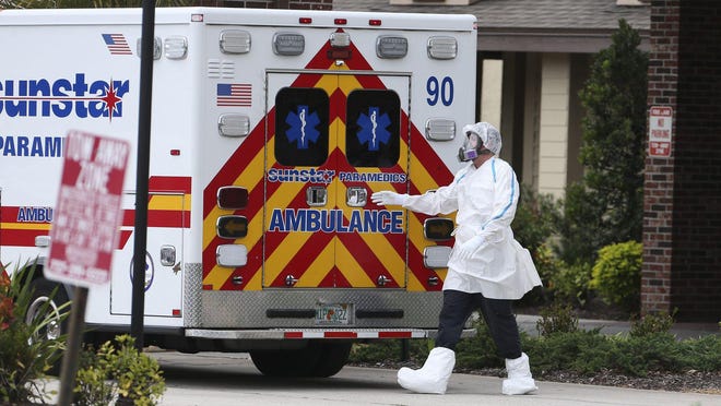Emergency personnel prepare to transport a patient by ambulance from the Freedom Square Seminole Nursing Pavilion in April. At least eight residents of the Seminole retirement community have died from the novel coronavirus. [DIRK SHADD / Times]
