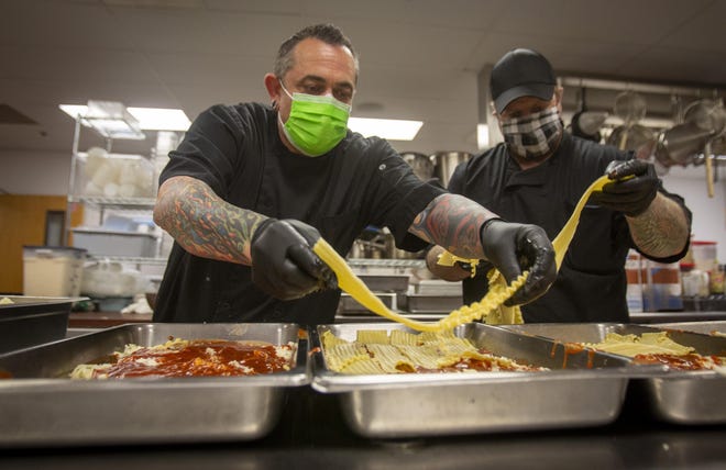 The Lane Community College Center for Meeting and Learning’s Lane Catering banquet chef Adam Hammel, left, and banquet coordinator Donnie Smith work to prepare lasagna with excess ingredients they received from the Eugene Mission this week in the kitchen on the LCC campus. [Andy Nelson/The Register-Guard] - registerguard.com