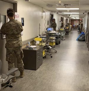 This photo provided by a hospital staff member shows Ohio National Guard members standing watch outside rooms of prison inmates that are being treated for the coronavirus at the Wexner Medical Center.