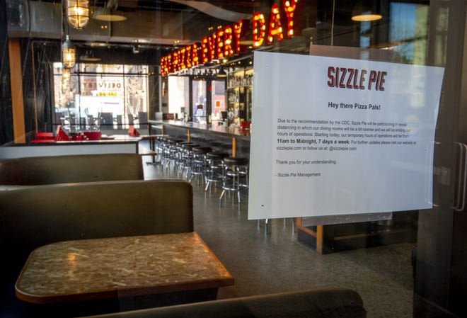 A sign in Sizzle Pie’s window March 16 explains their policies in response to COVID-19. [Andy Nelson/The Register-Guard file] - registerguard.com