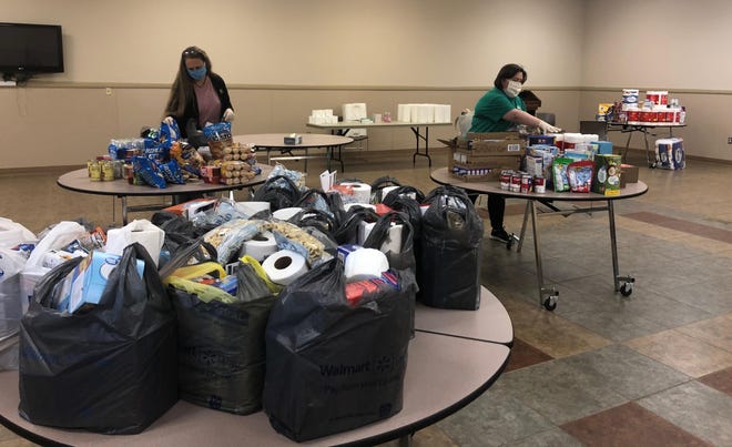 Staff members Karen Grigg and Glenda Hopkins are assembling bags of donated food to distribute to local seniors at the Patrick Senior Center. [Special to The Star]
