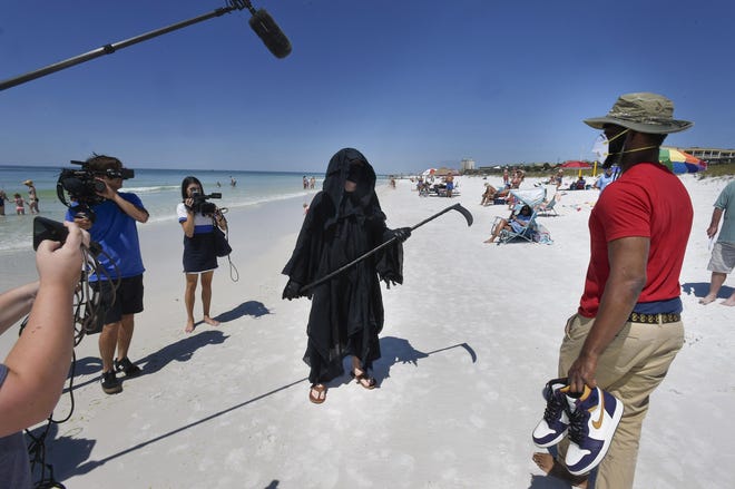 Dressed as the Grim Reaper, Florida Attorney Daniel Uhlfelder talks with reporters after walking the newly opened beach near Destin, Florida on Friday, May 1, 2020. Uhlfelder was protesting the Walton County (Florida) Commission's decision to reopen the county's beaches in spite of the COVID-19 pandemic. “In these circumstances, I can see no rational reason to open our beaches, effectively inviting tens of thousands of tourists back into our community” Uhlfelder said in a news release. “If by dressing up as the ‘Grim Reaper’ and walking our beaches I can make people think and potentially help save a life – that is the right thing to do.” [DEVON RAVINE/NORTHWEST FLORIDA DAILY NEWS]