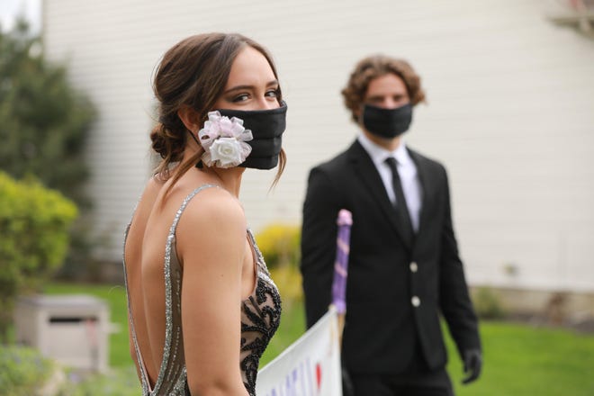 Grace Runkle's prom corsage was pinned to her coronavirus mask as her boyfriend, Luke Twiss, hosted a surprise prom at his Canal Winchester house. [Doral Chenoweth/Dispatch]