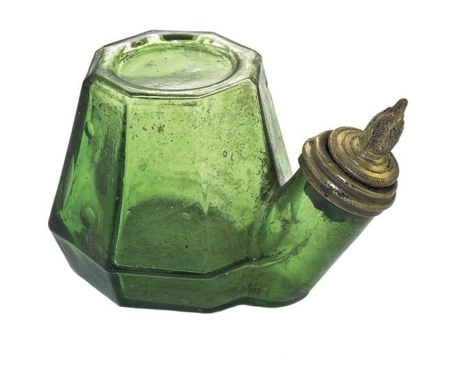 This green glass inkwell was made about 1880 in France. It is about 2 inches tall and has an unusual brass cap. It sold for $2,691 at an online-only auction by Glass Works Auctions of Pennsylvania. [Cowles Syndicate]