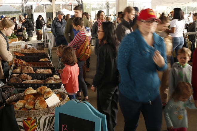 Locals packed the Athens Farmers Market as it kicked off its session in March 2018 at Bishop Park in Athens. The market will reopen this week, though it asks customers to order online when possible. (File/Joshua L. Jones, Athens Banner-Herald)