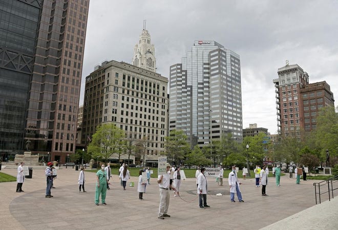 Dozens donned masks along with scrubs and white coats as the Physicians Action Network held a public rally in support of Dr. Amy Acton at the Ohio Statehouse on Sunday, May 3. Doctors stood 6 feet apart, marked by lengths of rope, to highlight the value of social distancing during the COVID-19 pandemic. The rally was a response to protesters who demonstrated outside Acton's home in Bexley on Saturday.