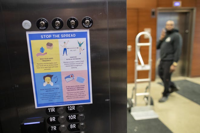 Signs inside the elevators of the 250 South High Street building Downtown give tips on how to slow the spread of COVID-19 on Friday, May 1, 2020. [Adam Cairns/Dispatch]