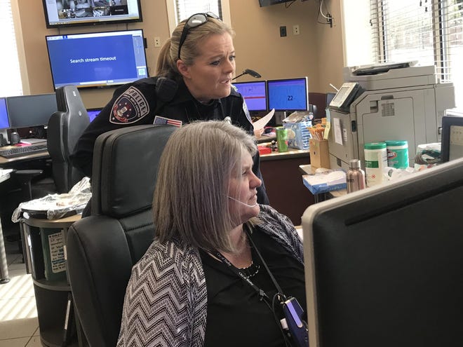 Shelby Officer Shannon Scell talks with dispatcher Christy Huggins about two suspects in a stolen vehicle case. [Joyce Orlando/The Star]