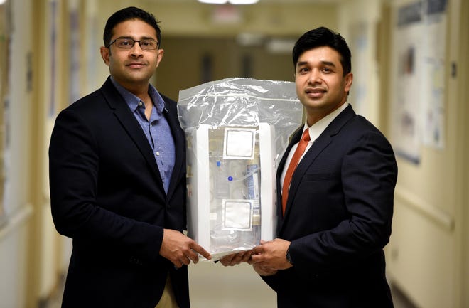 Dr. Azeem Mohammed, left, and Dr. Sandeep Padala hold one of the filters that may be able to help critically ill COVID-19 patients at Augusta University. [MICHAEL HOLAHAN/THE AUGUSTA CHRONICLE]