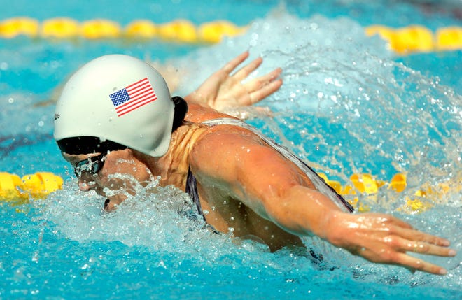 FILE - In this Aug. 14, 2004, file photo, Jenny Thompson swims during a qualifying heat of the 100 meter butterfly at the Olympic Aquatic Centre during the 2004 Olympic Games in Athens. One of America's greatest Olympic swimmers, Thompson is now on the front line of the fight against coronavirus as an anesthesiologist at the VA hospital in Charleston, South Carolina. (AP Photo/Mark J. Terrill, File)