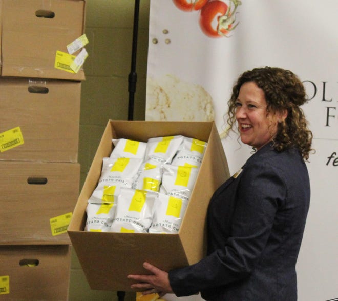 Golden Harvest Food Bank executive director Amy Breitmann with part of Augusta National Golf Club’s donation, which included potato chips originally destined for the concession stand. The donation consisted of 2,000 pounds of produce, bread and dairy products and 50,000 bags of chips. [WILL CHENEY/THE AUGUSTA CHRONICLE]