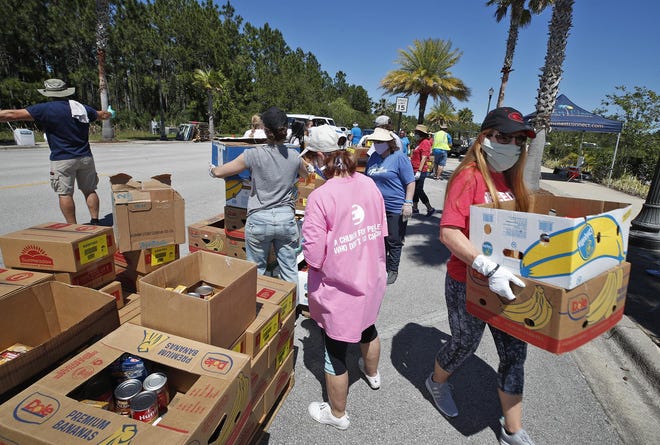 Volunteers loads boxes of food in to cars during The Feed Palm Coast Initiative in Palm Coast, Saturday, May 2, 2020. [News-Journal/Nigel Cook]