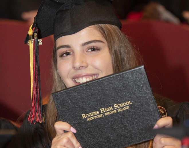 Aubrey Baker shows off her diploma after the 2019 graduation ceremony at Rogers High School. [DAILY NEWS FILE PHOTO]