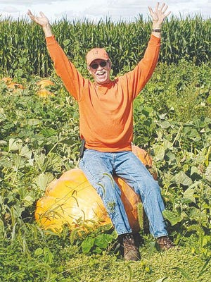Pumpkin King Bruce "O'Lantern" Curry sits atop one of the many pumpkins available at Country Corners Farm Market and Pumpkin Patch outside of Alpha.