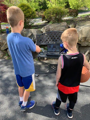 Mason and Logan Reed, a fifth and first grader, respectively, from Sparta, look on as Brian Thomas leads an online basketball workout. Thomas has been leading online workouts since the coronavirus pandemic forced his teams’ spring AAU season to be canceled. [Submitted photo]