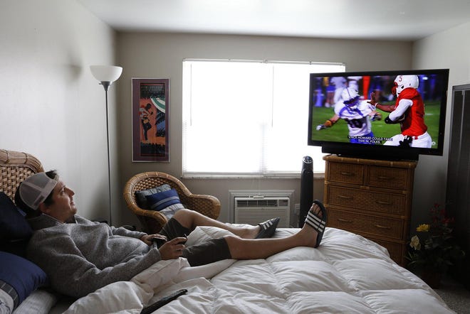 Steve Camp, a bartender laid off from 101 Beer Kitchen in Gahanna, watches television in his apartment on the Northwest Side. Camp has received unemployment and $600 a month in federal aid, but the bills still are piling up. [Eric Albrecht/Dispatch]