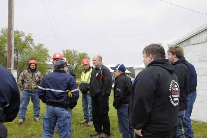 Department members of the Antrim Community Volunteer Fire Department look on as Chief Donald Warnock and Assistant Chief Don West talk to the staff of Surgent Construction, the contractors for the department's new station.