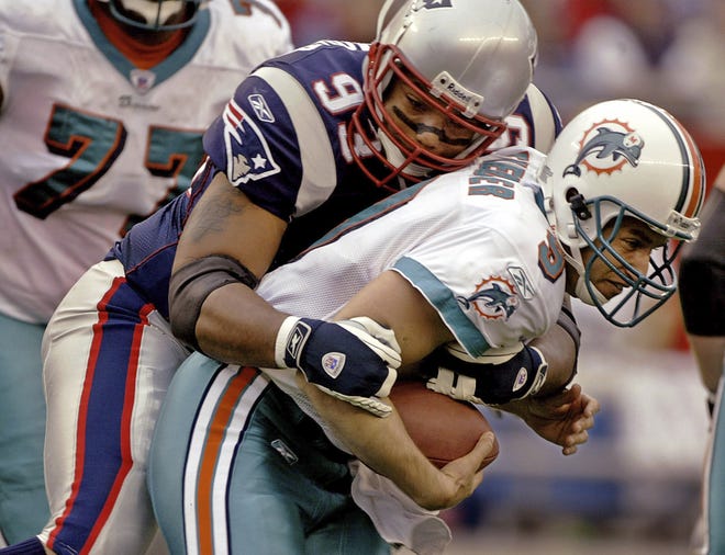 In this Oct. 10, 2004, file photo, Miami Dolphins quarterback Jay Fiedler (9) is sacked by New England Patriots defensive lineman Richard Seymour (93) during first-quarter action of their AFC East conference game in Foxboro. A member of New England's first three Super Bowl-winning teams in the 2001, 2003 and 2004 seasons, Seymour was announced on Monday, May 11, 2020, as the next inductee into the Patriots Hall of Fame. [Stephan Savoia/AP File Photo]