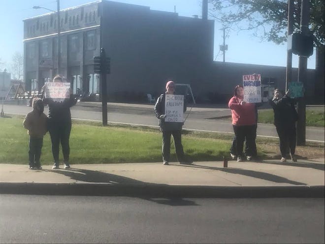 Several protestors seeking to re-open Ohio businesses and support National Road Diner owner Vicki Brearley while she attended a court hearing for violating Ohio Department of Health orders, gathered at the corner of Highland and Wheeling avenues in Cambridge Tuesday morning. [Rick Stillion, Daily-Jeff.com]