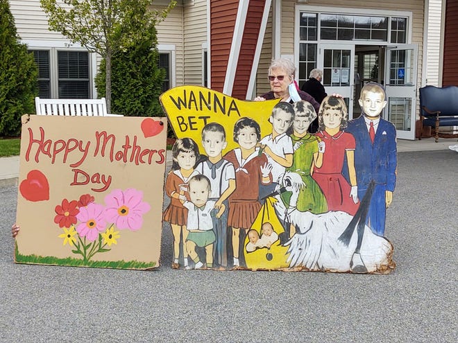 Former longtime Mansfield resident Joan Butler stands with a poster she made more than 50 years ago of her children. Her son Ken Butler restored it for a Mother’s Day Parade on Keystone Place at Buzzards Bay where Joan now resides on May 8.

[Courtesy]