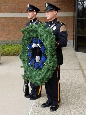 Deputies Matt VanLiere, right, and Aaron Overway place a wreath at the Ottawa County Police Officers Memorial on Sunday, May 10. The Annual Police Week memorial service was canceled due to the COVID-19 pandemic. [Courtesy]