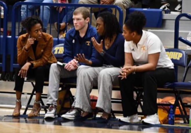 Effingham County’s new girls’ basketball coach Monica James, in blue shirt, third from left, talks with Troup County coaches during a game. James brings a winning tradition to the Rebels after helping Troup advance to the Class 4A state championship game last season. [COURTESY MONICA JAMES]
