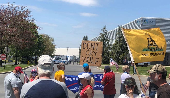 Trump supporters wait on the streets of Upper Macungie Township in the Lehigh Valley in anticpation of President Donald Trump’s arrival. Some fans held signs critical of Gov. Tom Wolf. [KATHRYNE RUBRIGHT/POCONO RECORD]