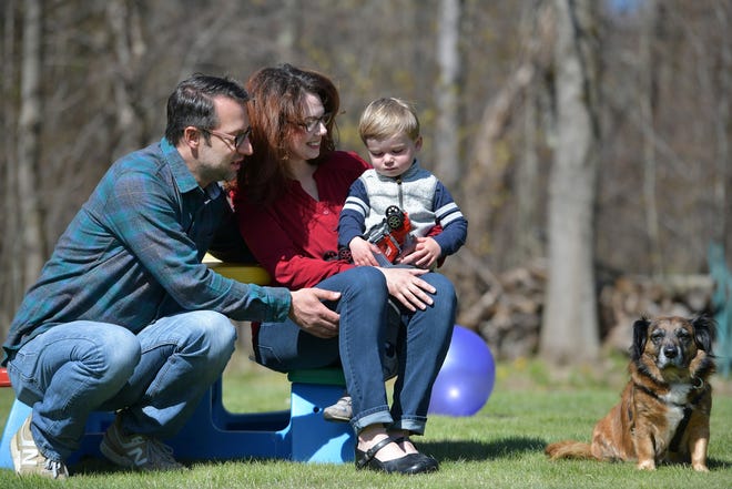 Mike and Sarah Dudek play their son Theo, 2, and their dog, Beo, in their Paxton backyard. The family has been coping with the state's stay-at-home advisory with new routines and activities. [T&G Staff/Christine Peterson]
