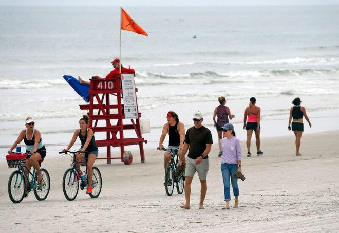 Beachgoers look to enjoy the beach under partly cloudy skies in New Smyrna Beach, Saturday, April 25, 2020. Volusia County limited the opening of its beaches and this week said the beaches could be fully reopened by the Memorial Day weekend. [News-Journal/Nigel Cook]