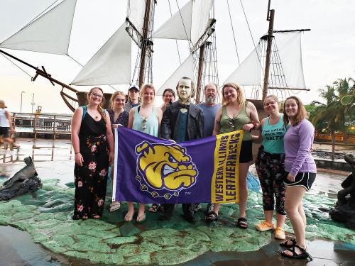 WIU students on the study abroad trip stand beside part of the Charles Darwin display. [Courtesy WIU]