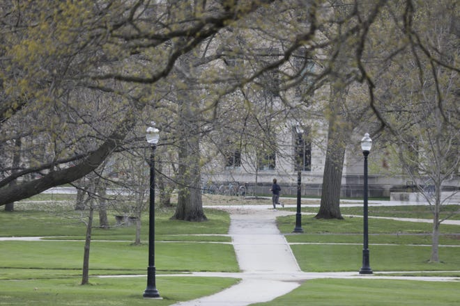 A woman runs around a deserted Oval on Tuesday, April 14, 2020 at Ohio State University in Columbus, Ohio. Ohio State, one of the country’s largest universities, is empty during what would normally be the end of the semester due to the ongoing COVID-19 pandemic. [Joshua A. Bickel/Dispatch]