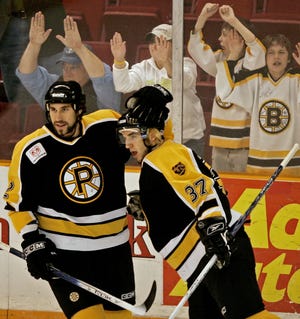 Providence Bruins coach Jay Leach (left) shown celebrating a goal by a young Patrice Bergeron (37) during an AHL playoff game against the Philadelphia Phantoms in 2005 lements the lost AHL season due to the coronavirus pandemic. Leach has led the P-Bruins to first place in the AHL Eastern Conference and was looking to make a deep run in the Calder Cup Playoffs this season. [AP File Photo/Winslow Townson]