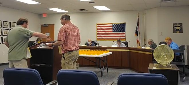 Two unmasked employees of the Summit County Board of Elections exchange ballot reports while addressing board members Tuesday. [Summit County Board of Elections Facebook page]