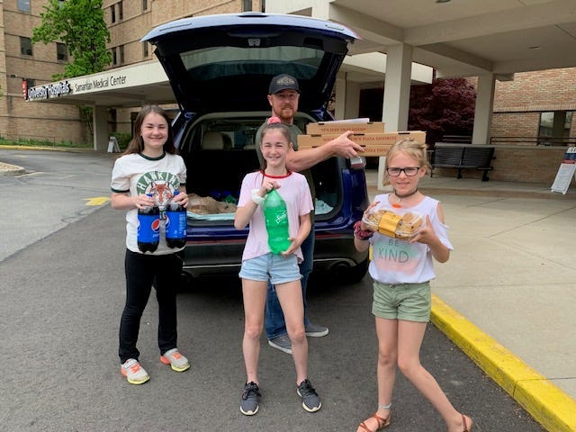 From left, Mallory Shields, 13, Addie Shields, 11 and Spencer Mott, 8, with Robin Shields unloading the pizzas, get ready to feed ER staff at University Hospitals Samaritan Medical Center. The girls' lemonade stand money provided pizza for ER staff at three Ohio hospitals.