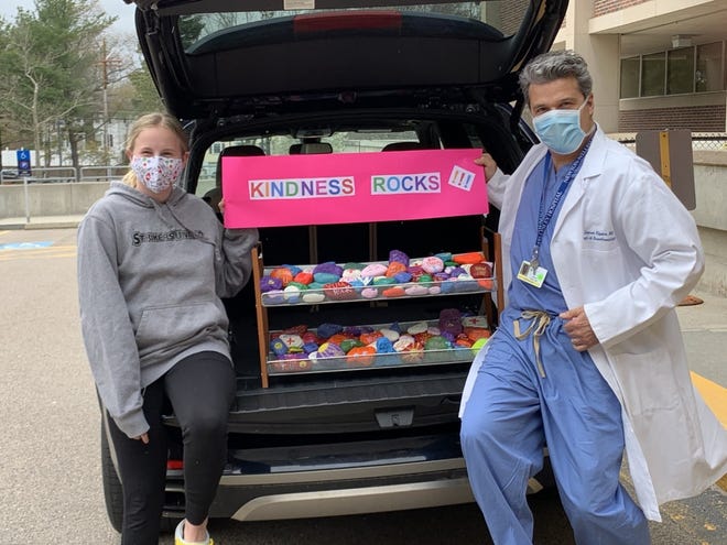 Phoebe Lewis, left, of Concord, recently delivered some of her painted rocks to Dr. James Alpers, an anesthesiologist at Newton-Wellesley Hospital.  [Courtesy Photo]