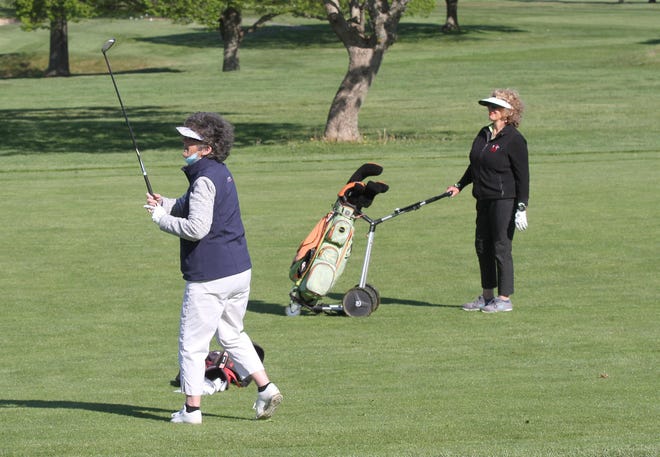 Brenda Shore watches her approach shot from the first fairway as playing partner Judith Rosenthal looks on at Wanumetonomy Golf & Country Club. [SCOTT BARRETT/DAILY NEWS PHOTO]