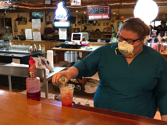 A Spanky D’s Restaurant and Boat Yard Bar employee pours a tequila sunrise Friday. The Bridgewater restaurant, like other Beaver County dining establishments, is selling cocktails to-go under a new Pennsylvania law designed to help establishments that have lost business due to the pandemic. [Scott Tady/BCT Staff]