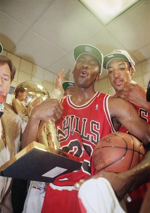 Michael Jordan holds the championship trophy after the 1993 playoffs and the Bulls’ first three-peat as NBA champs. [AP File]