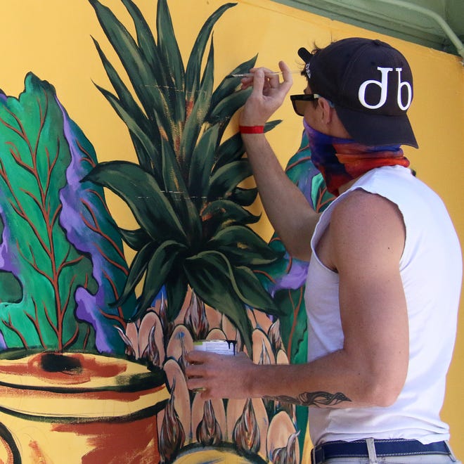 Joshua Wilmoth paints a mural in Provincetown. [BANNER PHOTO BY WILLIAM F. POMEROY]