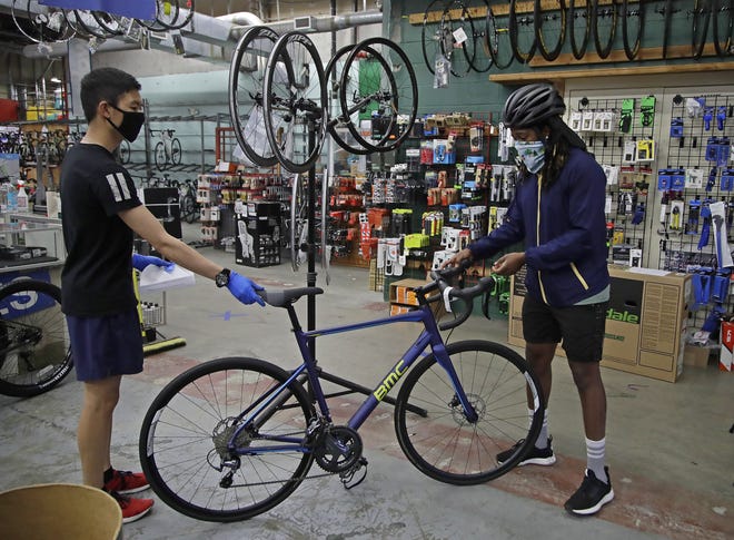 On Friday, May 15, Joel Johnson, right, takes delivery of his new bicycle at the Sports Basement store in San Francisco. Johnson hadn't owned a bicycle since he was 15, but soon after the coronavirus pandemic led to a shelter in place order in San Francisco, he bought a bike to avoid crowded public trains and buses. He is among thousands of cooped-up Americans snapping up new bicycles or dusting off decades-old bikes to stay fit, keep their mental sanity or have a safe alternative to public transportation. (AP Photo/Ben Margot)