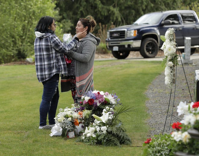 Antonia Lopez, right, is comforted by daughter Elda, 16, at Mountain View Cemetery in Auburn, Wash., last month after they had placed flowers at the grave of Antonia’s husband, Tomas, 44, who died of COVID-19 three weeks earlier. [Ted S. Warren/The Associated Press]