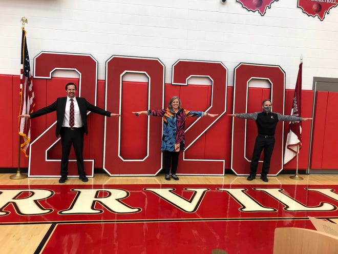 Orrville High School Principal Tim Adams (from left), retiring guidance counselor Laurier Likens and Assistant Principal Doug Davault demonstrate social distancing for a photo after the Class of 2020 graduation on May 16. Likens is retiring after 37 years in education.