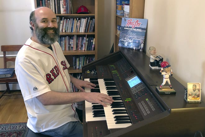 In this April 2020 photo provided by Josh Kantor, the Boston Red Sox organist plays the organ in his home in Cambridge. Each afternoon since what would have been opening day, Kantor has been live-streaming concerts of ballpark music and other fan requests from his home in an attempt to recreate the community feeling baseball fans might be missing while the sport is shut down during the coronavirus pandemic. [Mary Eaton/Josh Kantor via AP]