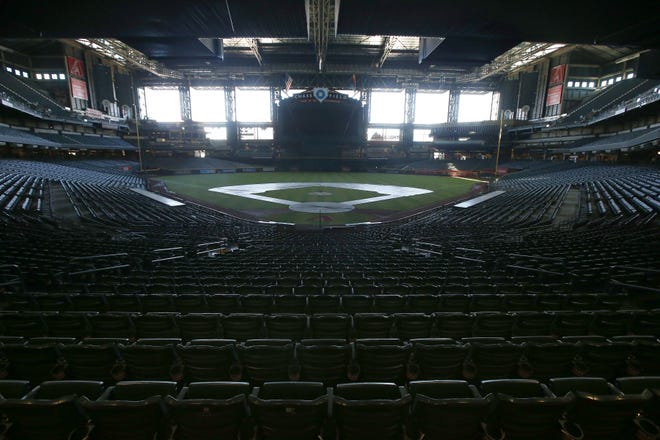 In this Tuesday, April 28, 2020, file photo, a darkened Chase Field, home of the Arizona Diamondbacks, sits empty. (AP File Photo/Ross D. Franklin)