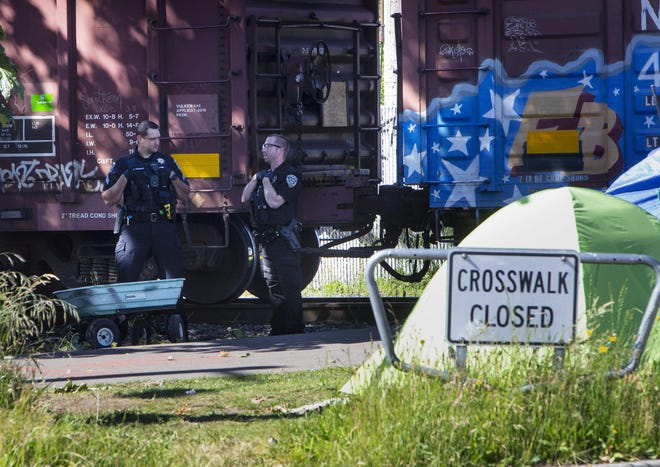 Police stand by at the scene of an accident where a man was hit by a train Wednesday afternoon near Hilyard Street in Eugene. [Chris Pietsch/The Register-Guard] - registerguard.com